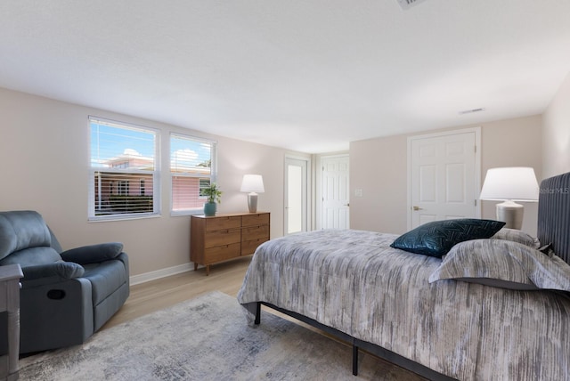 bedroom with light wood-type flooring and baseboards