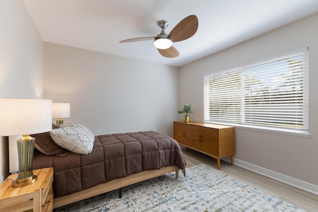 bedroom featuring wood finished floors, baseboards, and ceiling fan