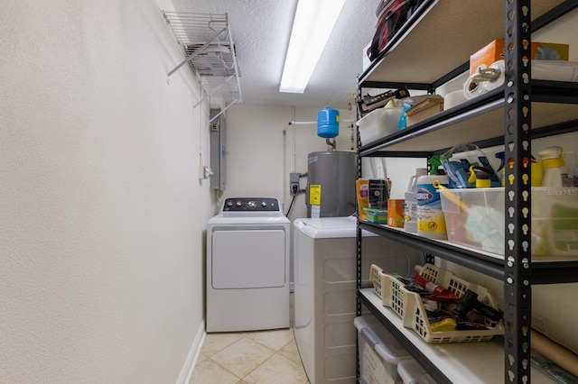 laundry room with water heater, washing machine and clothes dryer, baseboards, and tile patterned floors