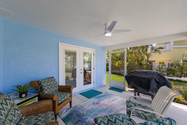 sunroom / solarium featuring french doors and a ceiling fan