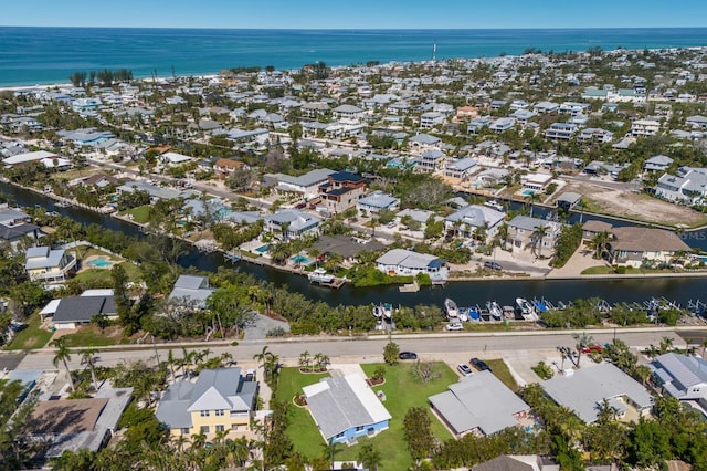 aerial view of property and surrounding area with a large body of water and nearby suburban area