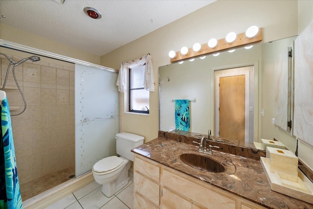 9089 Berendo Ave, Englewood, FL 34224 - bathroom featuring tiled shower, vanity, toilet, tile patterned floors, and a textured ceiling
