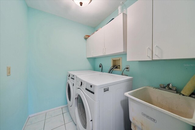 9089 Berendo Ave, Englewood, FL 34224 - washroom featuring cabinet space, separate washer and dryer, baseboards, and light tile patterned floors