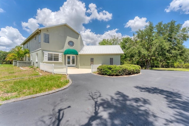 919 Palm View Way, Sarasota, FL 34240 - view of front of house with french doors, stucco siding, driveway, and metal roof