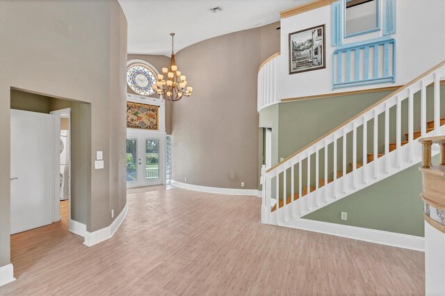 919 Palm View Way, Sarasota, FL 34240 - foyer entrance with wood finished floors, stairway, a towering ceiling, a chandelier, and baseboards