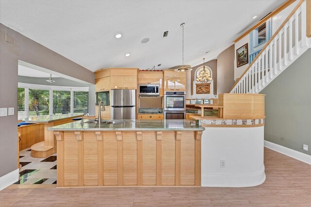 919 Palm View Way, Sarasota, FL 34240 - kitchen with stainless steel appliances, a sink, light brown cabinetry, a large island with sink, and baseboards