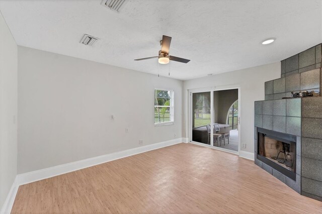 919 Palm View Way, Sarasota, FL 34240 - unfurnished living room with wood finished floors, a tiled fireplace, ceiling fan, and baseboards