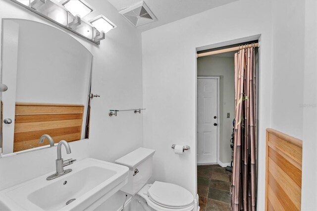 919 Palm View Way, Sarasota, FL 34240 - bathroom featuring a sink, stone tile floors, and toilet
