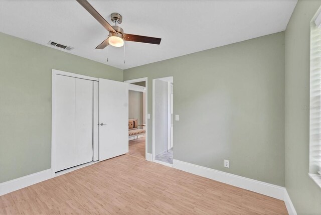 919 Palm View Way, Sarasota, FL 34240 - unfurnished bedroom with wood finished floors, a closet, ceiling fan, and baseboards