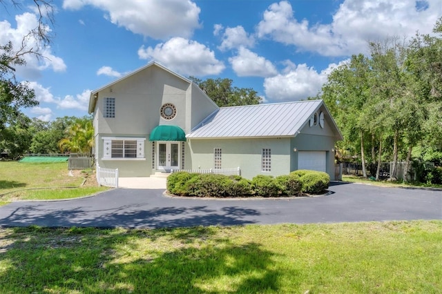 919 Palm View Way, Sarasota, FL 34240 - view of front of property featuring french doors, stucco siding, asphalt driveway, metal roof, and a garage