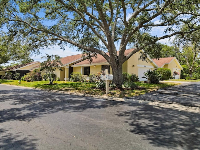 4203 Carriage Dr Unit 27, Sarasota, FL 34241 - view of front of house featuring an attached garage, stucco siding, and driveway