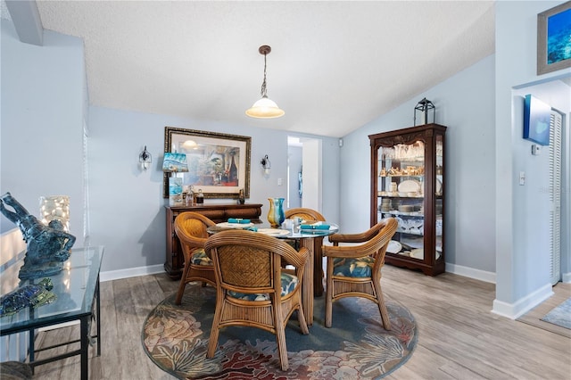 4203 Carriage Dr Unit 27, Sarasota, FL 34241 - dining area featuring vaulted ceiling, baseboards, and light wood-style floors