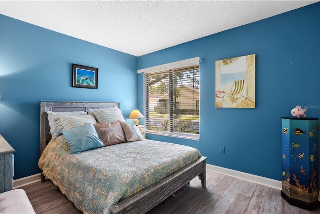 4203 Carriage Dr Unit 27, Sarasota, FL 34241 - bedroom with baseboards, wood finished floors, and a textured ceiling