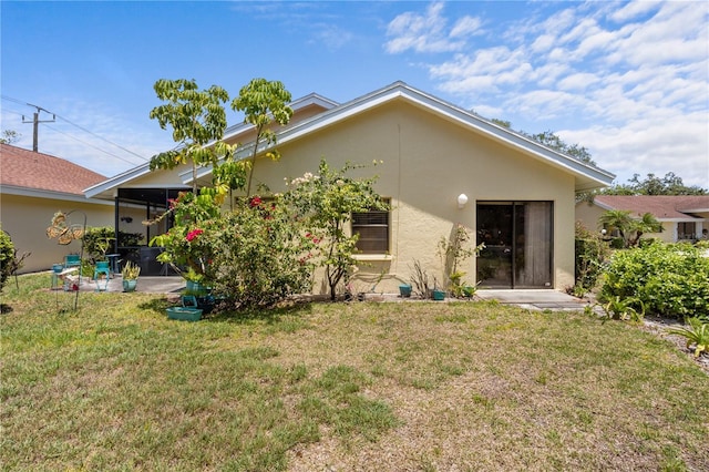 4203 Carriage Dr Unit 27, Sarasota, FL 34241 - rear view of house featuring stucco siding and a yard