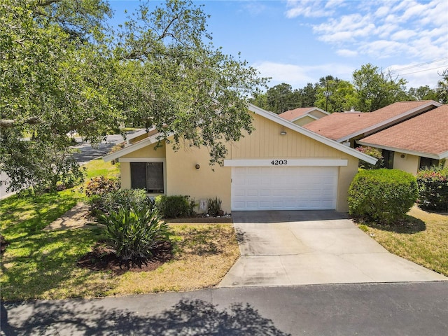 4203 Carriage Dr Unit 27, Sarasota, FL 34241 - view of front of house with an attached garage, concrete driveway, and stucco siding