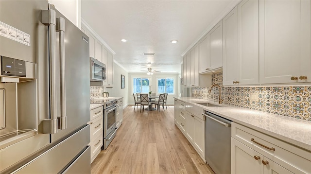 4665 Pine Harrier Dr, Sarasota, FL 34231 - kitchen featuring premium appliances, a sink, light wood-style flooring, recessed lighting, and tasteful backsplash