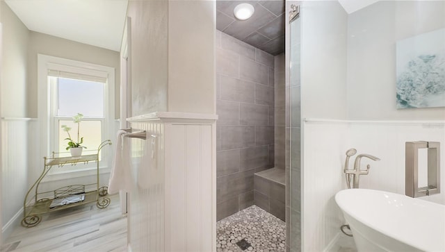 4665 Pine Harrier Dr, Sarasota, FL 34231 - full bath featuring a soaking tub, a tile shower, and wainscoting