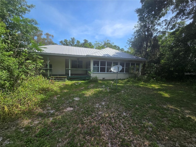 2905 Sunset Rd, Melbourne, FL 32904 - rear view of property with a porch, metal roof, and a yard
