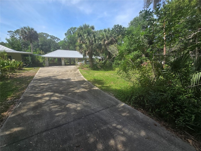 2905 Sunset Rd, Melbourne, FL 32904 - view of front facade with concrete driveway, a carport, and a front lawn