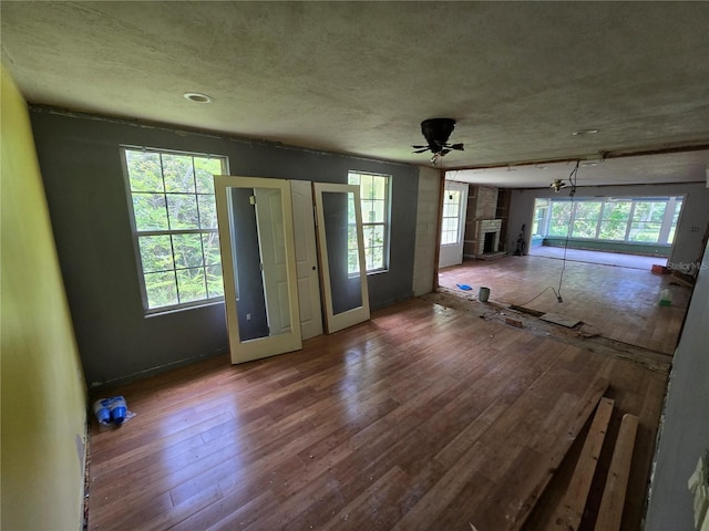 2905 Sunset Rd, Melbourne, FL 32904 - unfurnished living room featuring wood-type flooring and a tiled fireplace