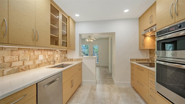 755 Edgemere Ln, Sarasota, FL 34242 - kitchen with appliances with stainless steel finishes, a sink, under cabinet range hood, tasteful backsplash, and glass insert cabinets