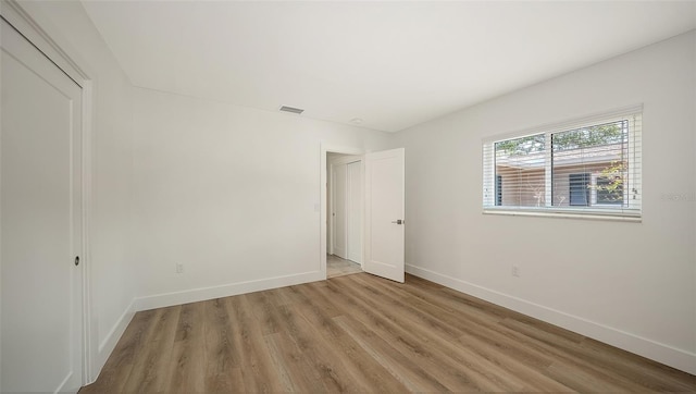 755 Edgemere Ln, Sarasota, FL 34242 - unfurnished bedroom featuring baseboards, light wood-style flooring, and a closet