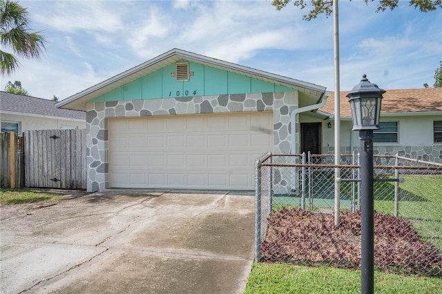 1004 65th Ave W, Bradenton, FL 34207 - view of front of property with an attached garage, driveway, stone siding, and board and batten siding