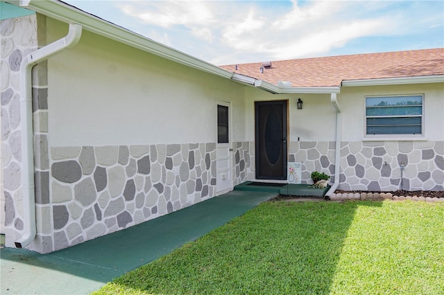 1004 65th Ave W, Bradenton, FL 34207 - doorway to property featuring a yard, a shingled roof, and stucco siding