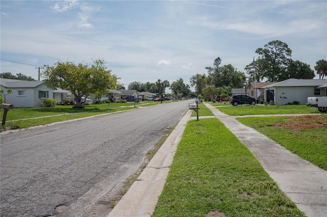 1004 65th Ave W, Bradenton, FL 34207 - view of asphalt road with a residential view, sidewalks, and curbs