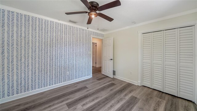 6990 Richardson Rd, Sarasota, FL 34240 - unfurnished bedroom with ornamental molding, wood finished floors, baseboards, ceiling fan, and a closet