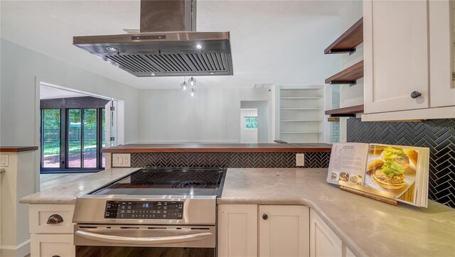 6990 Richardson Rd, Sarasota, FL 34240 - kitchen with electric range, island range hood, backsplash, and white cabinets