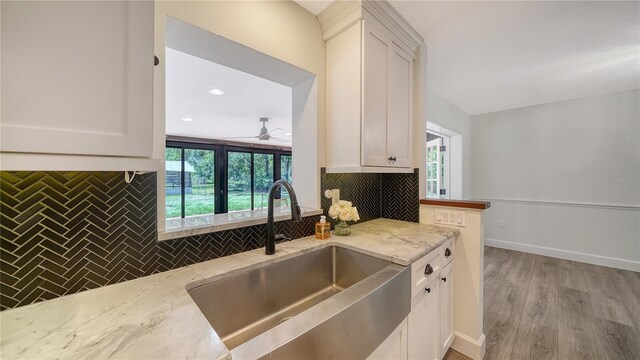 6990 Richardson Rd, Sarasota, FL 34240 - kitchen featuring a sink, tasteful backsplash, light stone countertops, ceiling fan, and white cabinets
