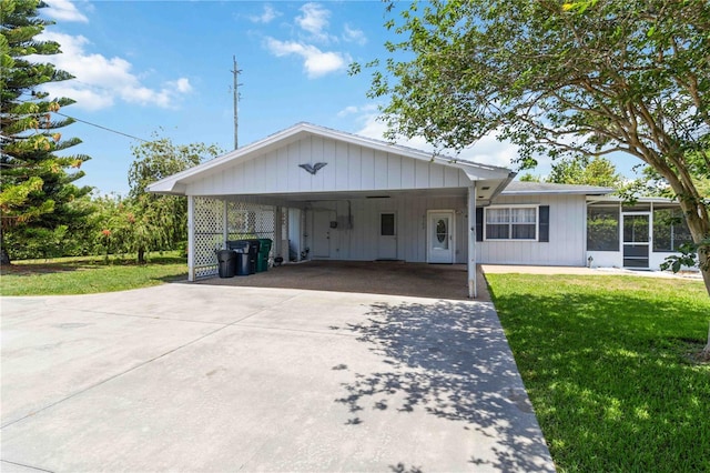 3102 SE 34th Ave, Okeechobee, FL 34974 - view of front facade with concrete driveway, a front yard, and a sunroom