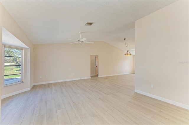 645 Liberty St, Englewood, FL 34223 - unfurnished room with ceiling fan, vaulted ceiling, light wood finished floors, baseboards, and a textured ceiling