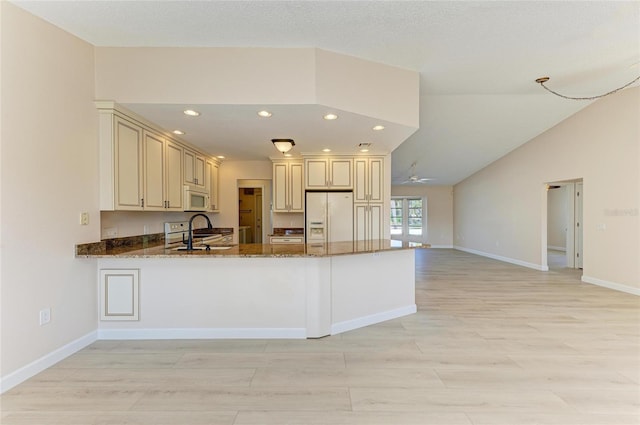 645 Liberty St, Englewood, FL 34223 - kitchen with white appliances, cream cabinetry, dark stone countertops, a ceiling fan, and recessed lighting