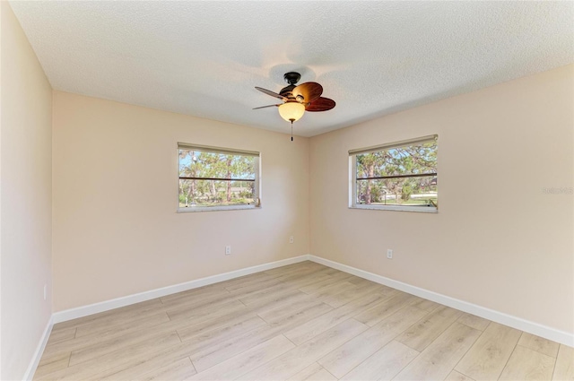 645 Liberty St, Englewood, FL 34223 - spare room with light wood-style flooring, healthy amount of natural light, a ceiling fan, baseboards, and a textured ceiling