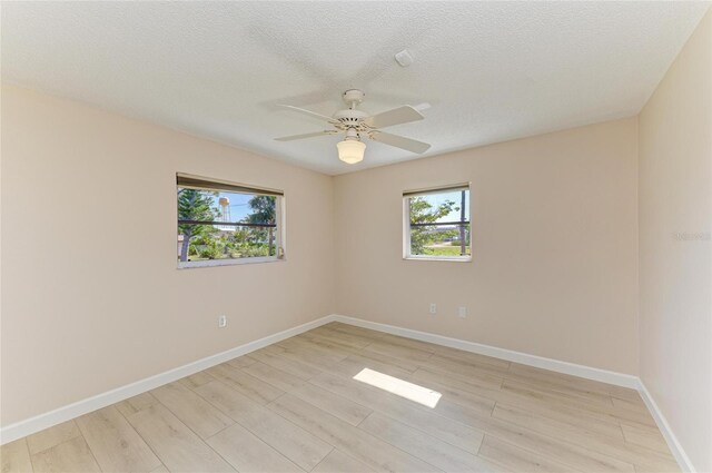 645 Liberty St, Englewood, FL 34223 - spare room with healthy amount of natural light, ceiling fan, light wood-type flooring, baseboards, and a textured ceiling
