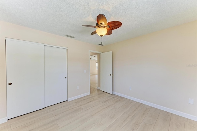 645 Liberty St, Englewood, FL 34223 - unfurnished bedroom featuring light wood-style floors, a closet, baseboards, a textured ceiling, and ceiling fan