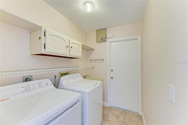 645 Liberty St, Englewood, FL 34223 - laundry room with cabinet space, a textured ceiling, washing machine and clothes dryer, baseboards, and light tile patterned floors