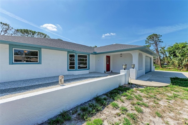 645 Liberty St, Englewood, FL 34223 - view of front facade with stucco siding, a garage, driveway, and a shingled roof