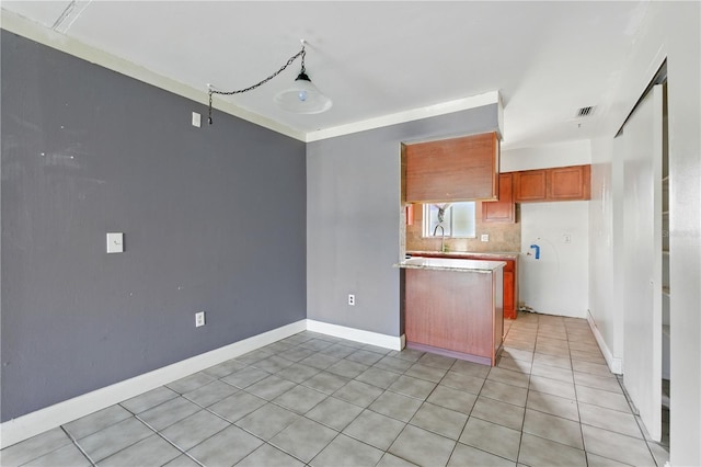 2704 Hidden Lake Blvd Unit C, Sarasota, FL 34237 - kitchen with light countertops, brown cabinetry, tasteful backsplash, and light tile patterned floors