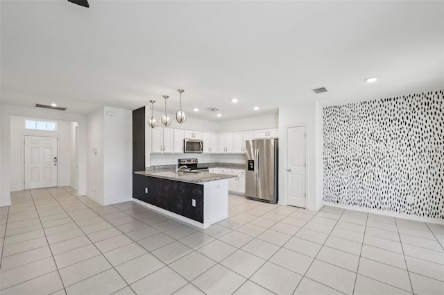 4503 Lindever Ln, Palmetto, FL 34221 - kitchen with stainless steel appliances, a peninsula, recessed lighting, white cabinets, and light stone counters