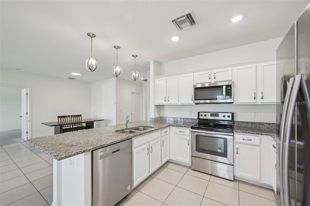 4503 Lindever Ln, Palmetto, FL 34221 - kitchen with stainless steel appliances, a sink, a peninsula, light tile patterned flooring, and white cabinets