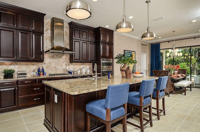 21225 Wacissa Dr, Venice, FL 34293 - kitchen with wall chimney range hood, a sink, appliances with stainless steel finishes, a breakfast bar, and recessed lighting