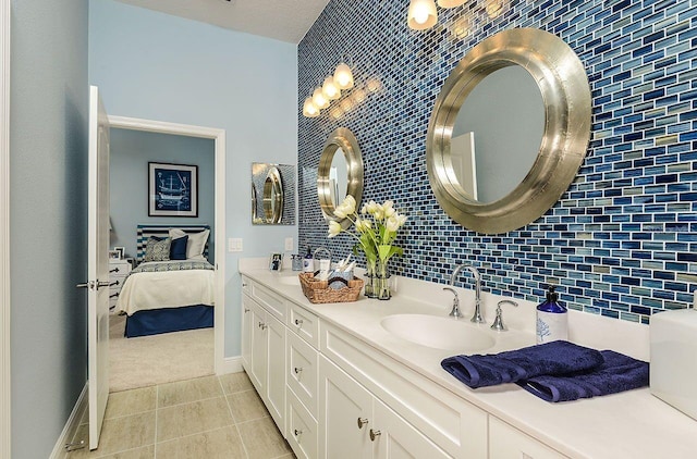21225 Wacissa Dr, Venice, FL 34293 - bathroom with double vanity, tile patterned floors, backsplash, baseboards, and ensuite bath
