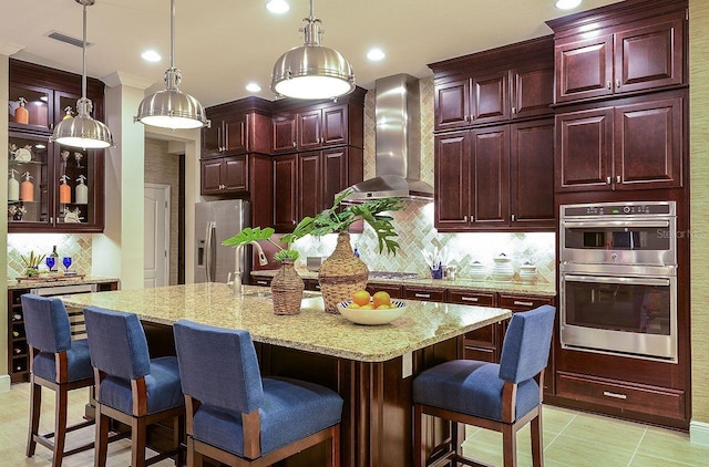 21225 Wacissa Dr, Venice, FL 34293 - kitchen featuring wall chimney exhaust hood, appliances with stainless steel finishes, backsplash, dark brown cabinets, and recessed lighting