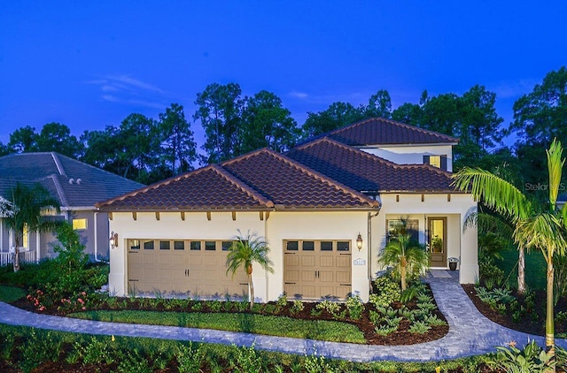21225 Wacissa Dr, Venice, FL 34293 - mediterranean / spanish-style house with a garage, a tiled roof, and stucco siding