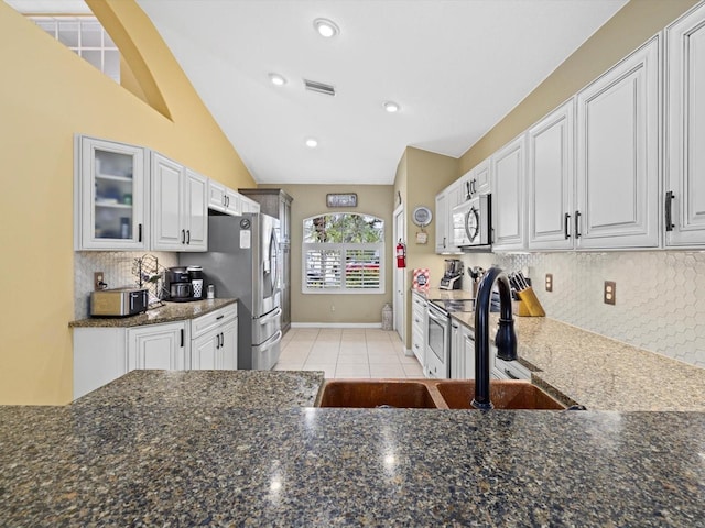 8222 Haven Harbour Way, Bradenton, FL 34212 - kitchen featuring stainless steel appliances, a sink, dark stone counters, glass insert cabinets, and light tile patterned flooring