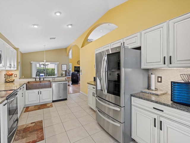 8222 Haven Harbour Way, Bradenton, FL 34212 - kitchen with lofted ceiling, appliances with stainless steel finishes, a sink, decorative backsplash, and white cabinets