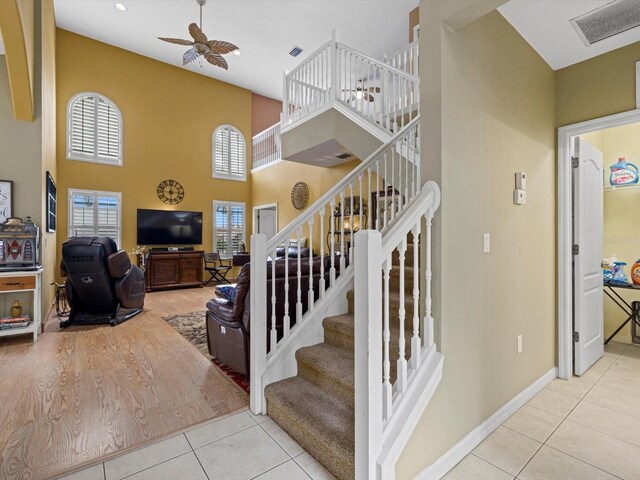 8222 Haven Harbour Way, Bradenton, FL 34212 - stairway featuring ceiling fan, tile patterned floors, a towering ceiling, and baseboards